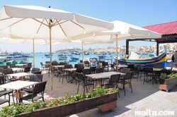 Bar and tables on the Marsaxlokk Bay promenade