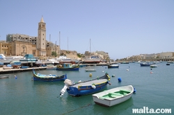 Marsascala's St Anne Church and luzzu on shore