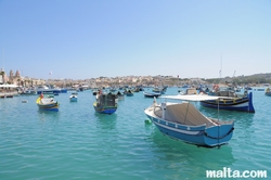 Boats and luzzu in the blue water of Marsaxlokk harbour Boats and luzzu in the blue water of Marsaxlokk harbour