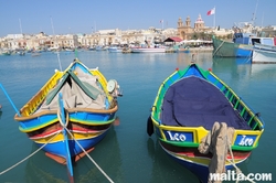 Luzzu and the Parish church in Marsaxlokk Luzzu and the Parish church in Marsaxlokk
