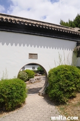 Round door between different gardens of the Garden of Serenity in Santa Lucija